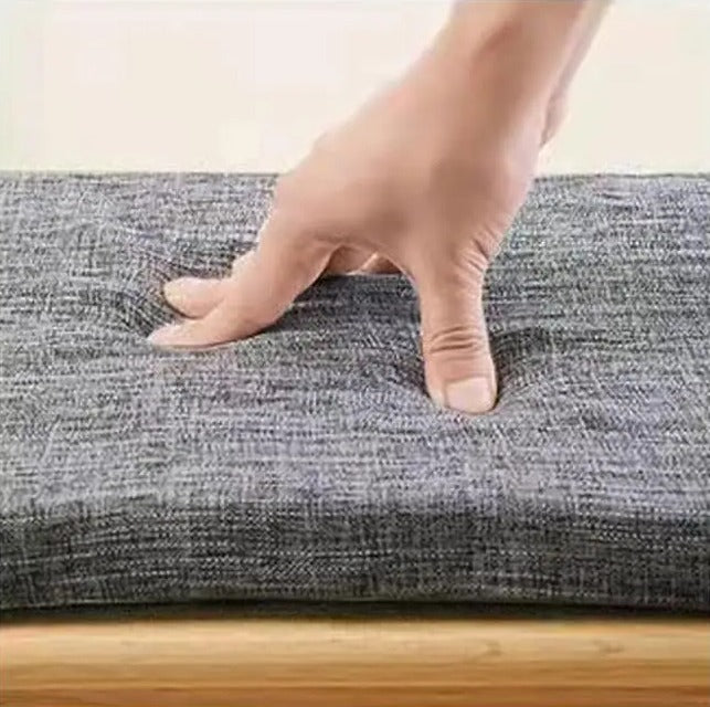 BANQUETTE — Main appuyant sur le coussin de banc gris en tissu texturé