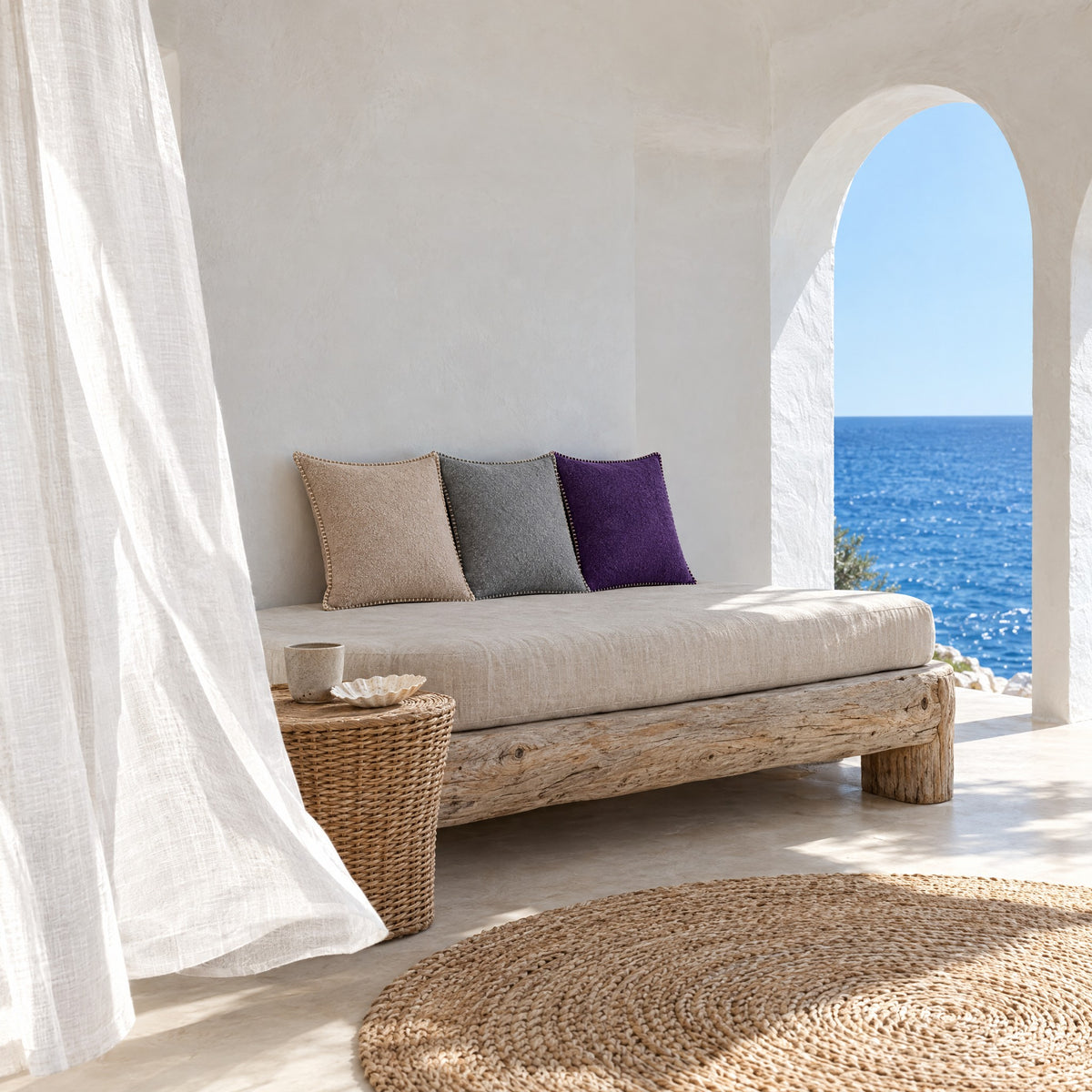 Lit de repos dans une loggia avec coussins GALON beige, gris clair et violet, voilages au vent