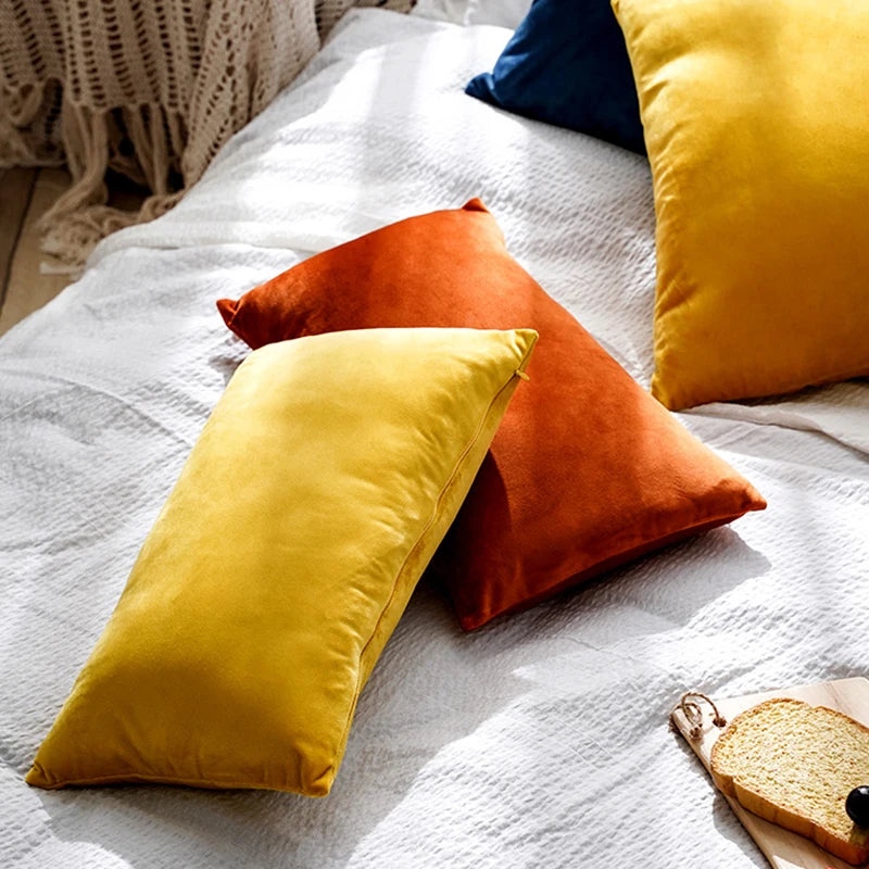 CARMIN — Housses de coussin rectangulaires en velours sur un lit, coloris jaune, orange et bleu nuit