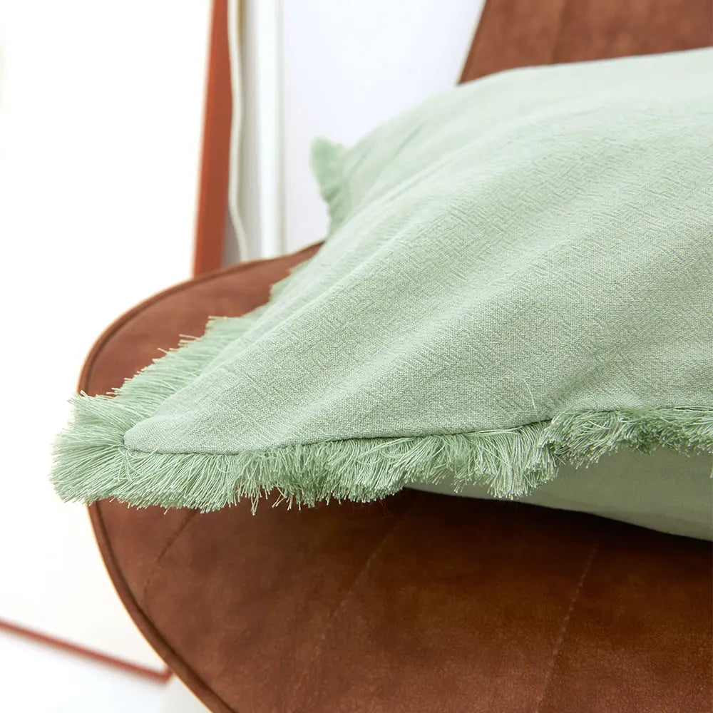 FRANGE — Gros plan sur les franges d'une housse de coussin, coloris Vert clair
