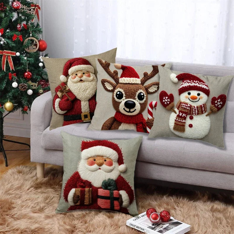 RENNE — Quatre housses de coussin de Noël Père Noël, renne et bonhomme de neige sur un canapé gris