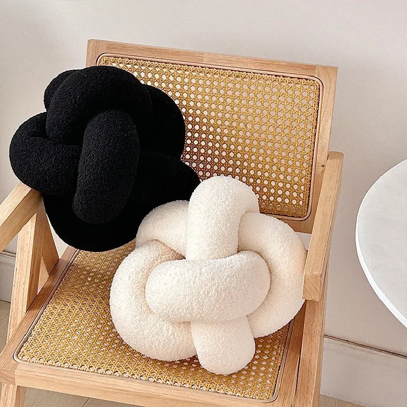 AGNEAU — Coussins boule noués effet laine d'agneau noir et crème sur fauteuil