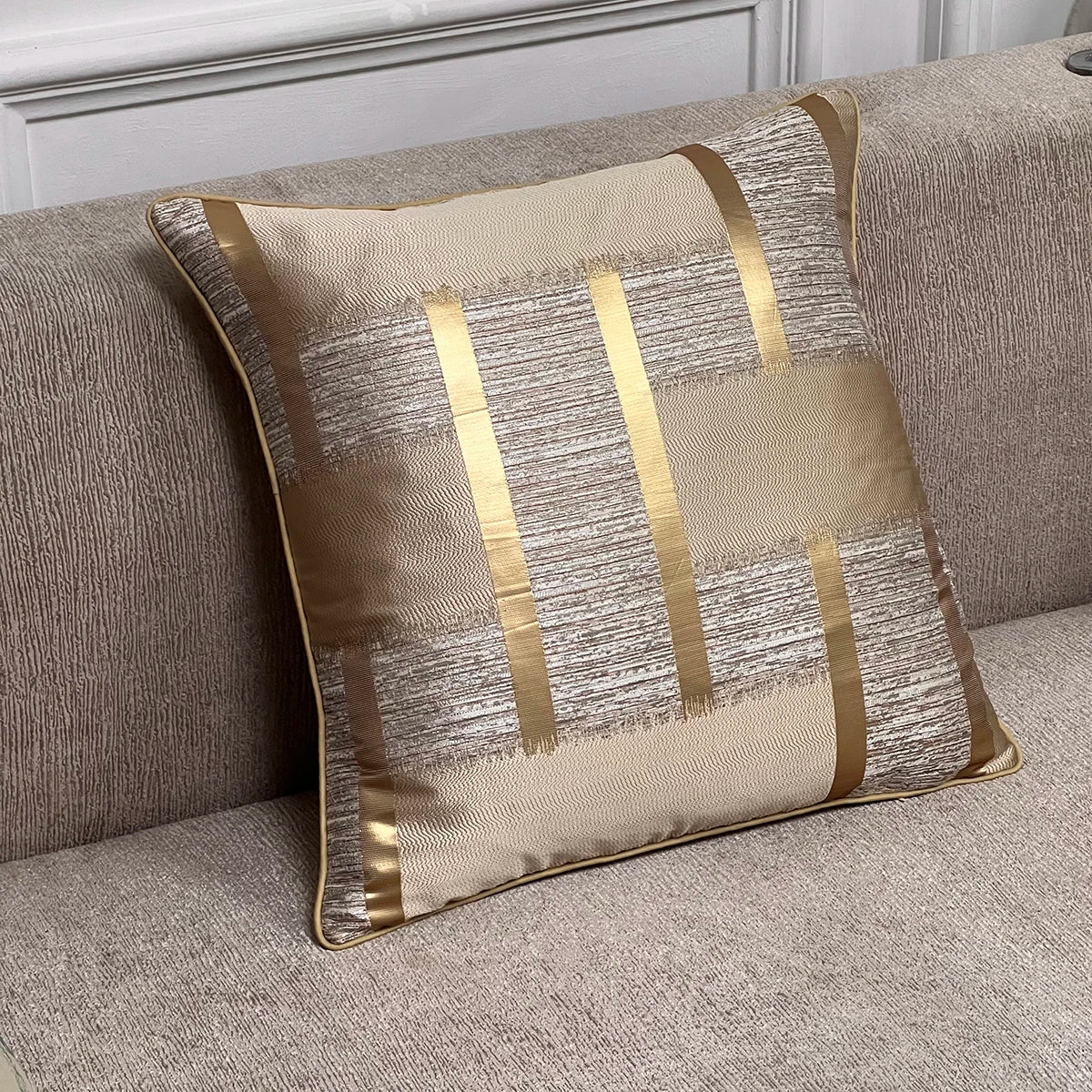 GATSBY — Housse de coussin art déco à rayures dorées et passepoil, coloris Beige et or, posée sur un canapé