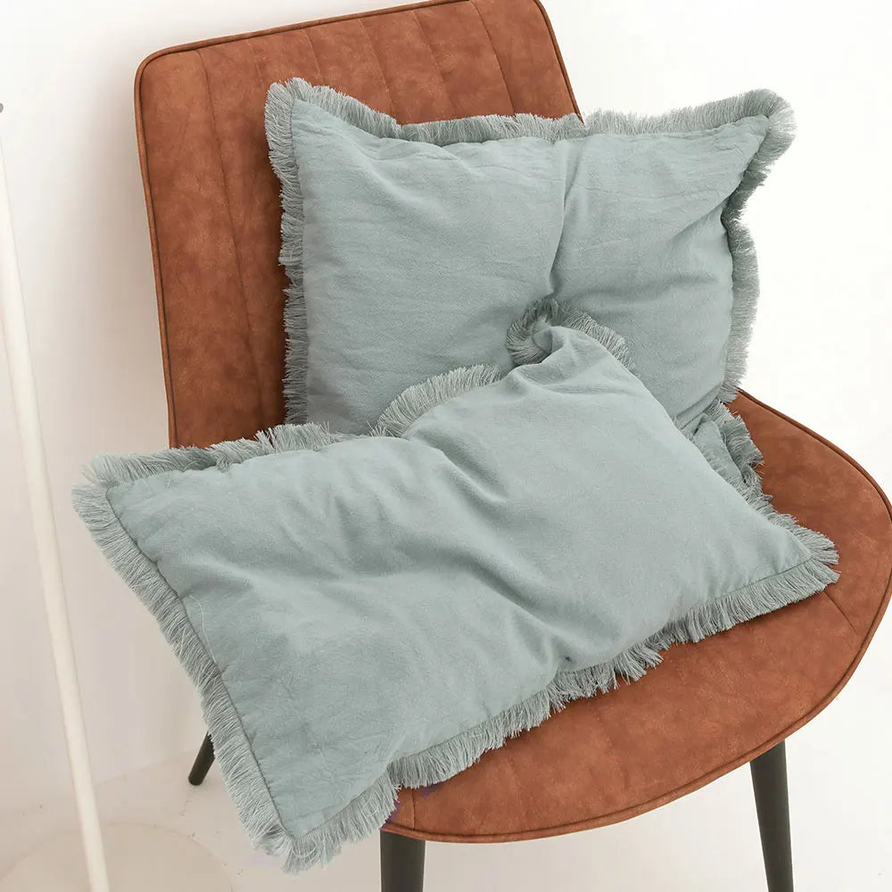 FRANGE — Deux housses de coussin à franges, coloris Bleu clair, formats carré et rectangulaire