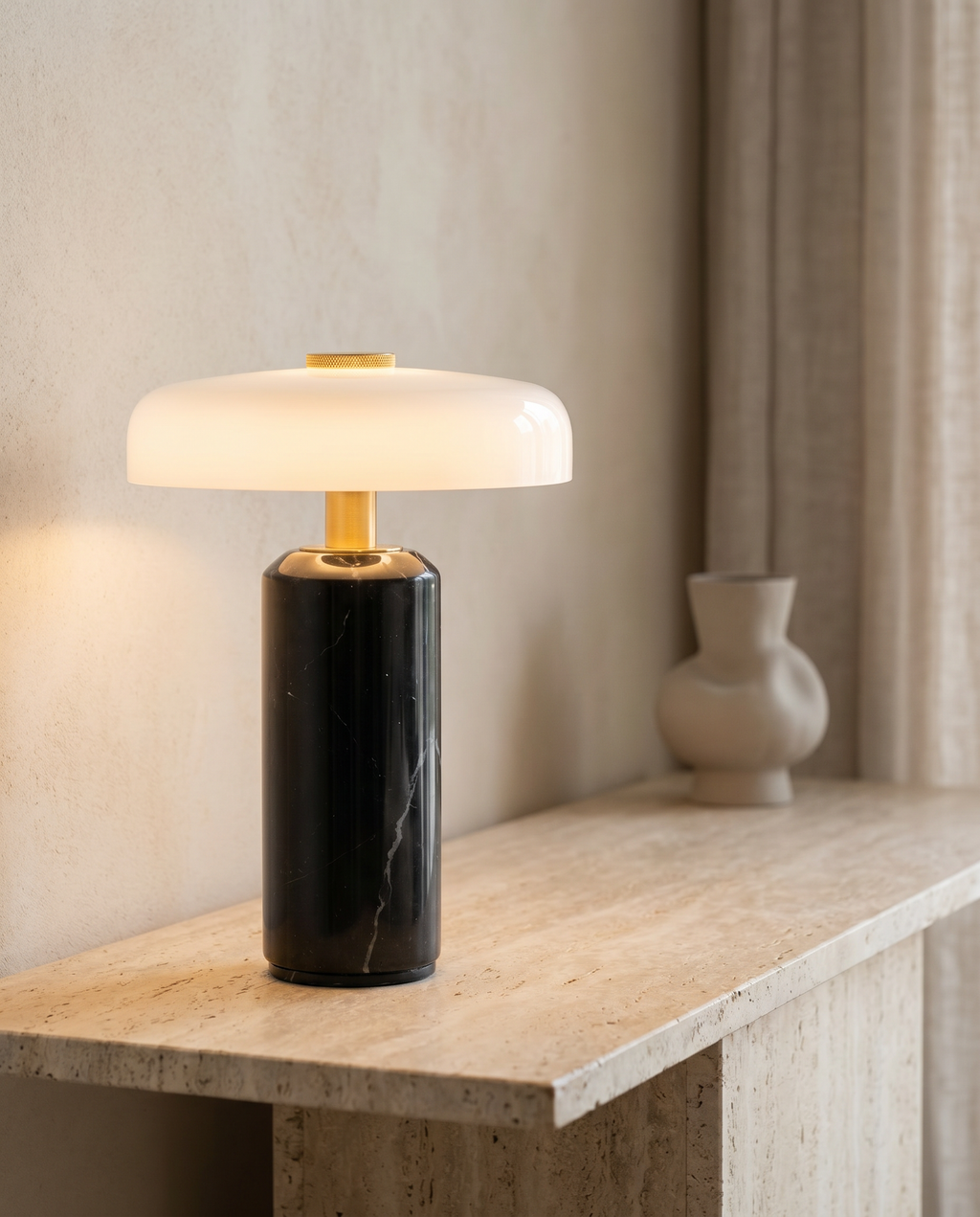 Lampe SÉLÈNE en marbre noir sur une console en travertin dans un salon premium