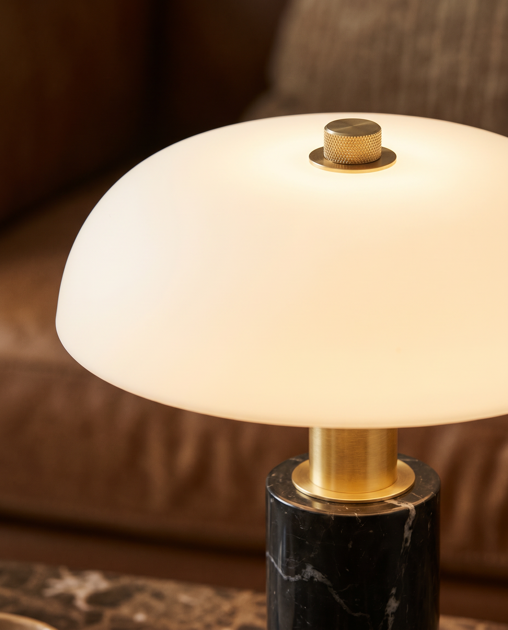 Détail du dôme opalin lumineux et du bouton tactile doré de la lampe SÉLÈNE