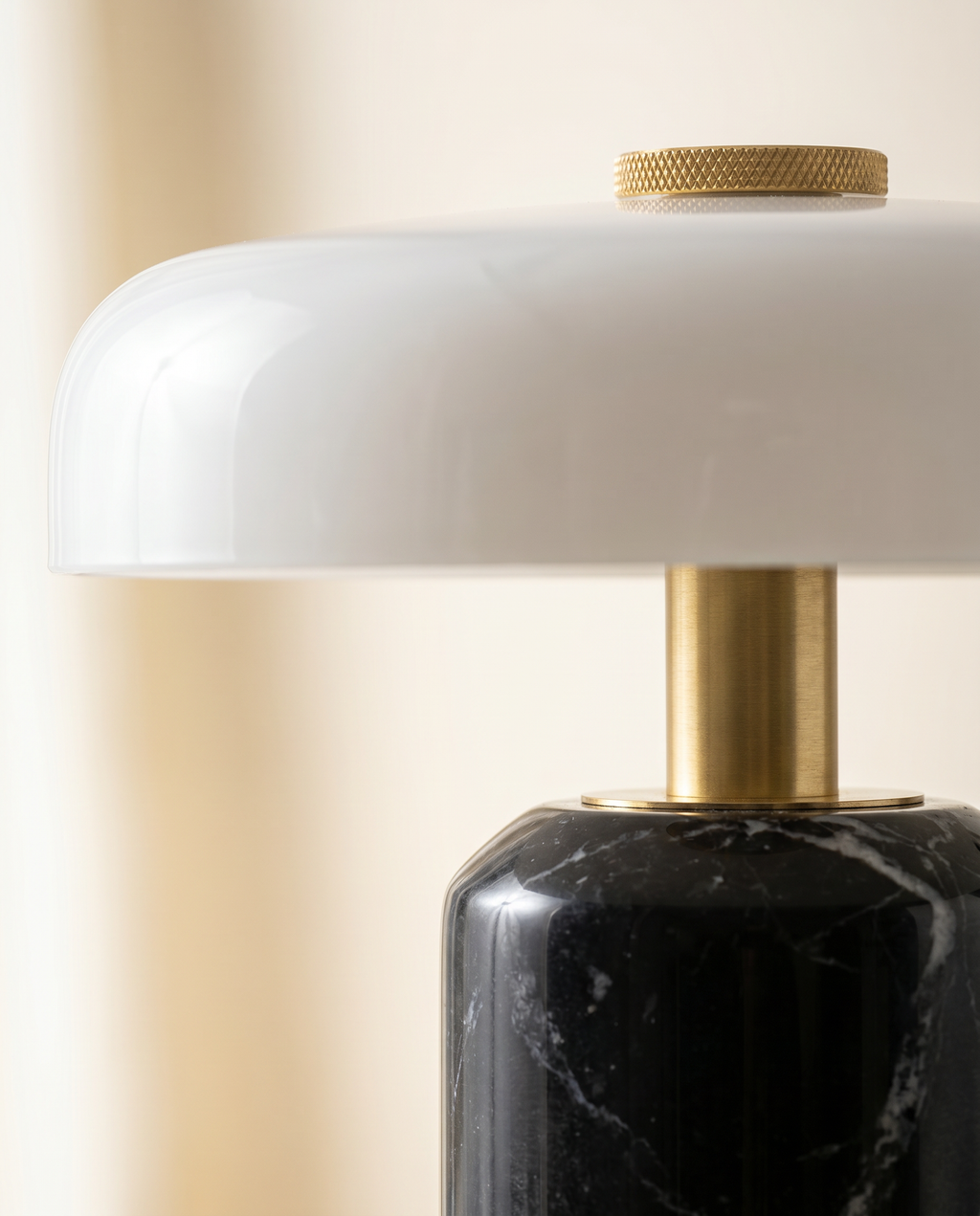 Macro du marbre noir veiné, du laiton doré et du verre opalin de la lampe SÉLÈNE