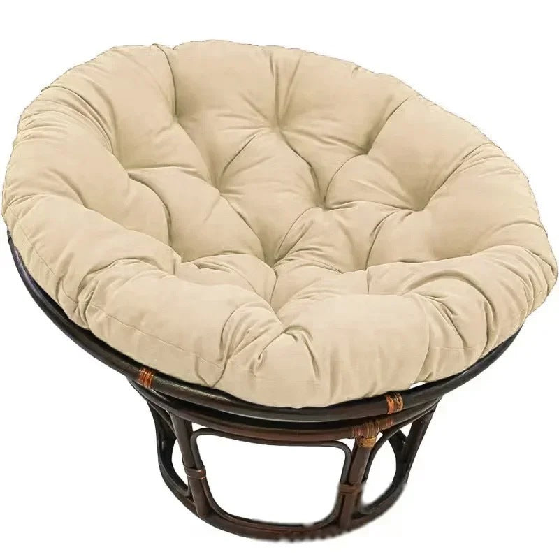 PAPASAN — Coussin rond capitonné coloris Beige posé sur un fauteuil papasan en rotin