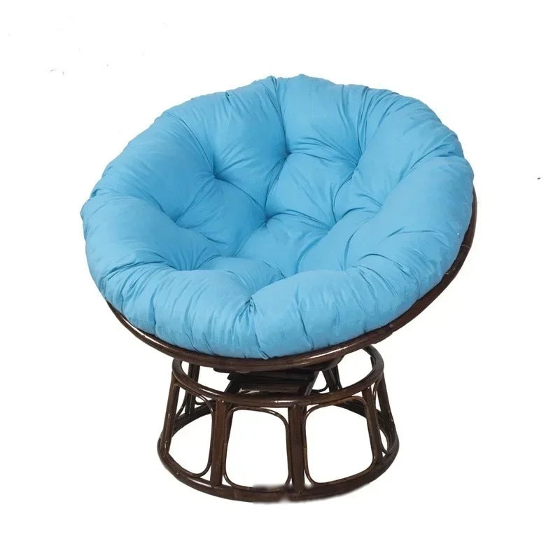 PAPASAN — Coussin rond capitonné coloris Bleu ciel posé sur un fauteuil papasan en rotin