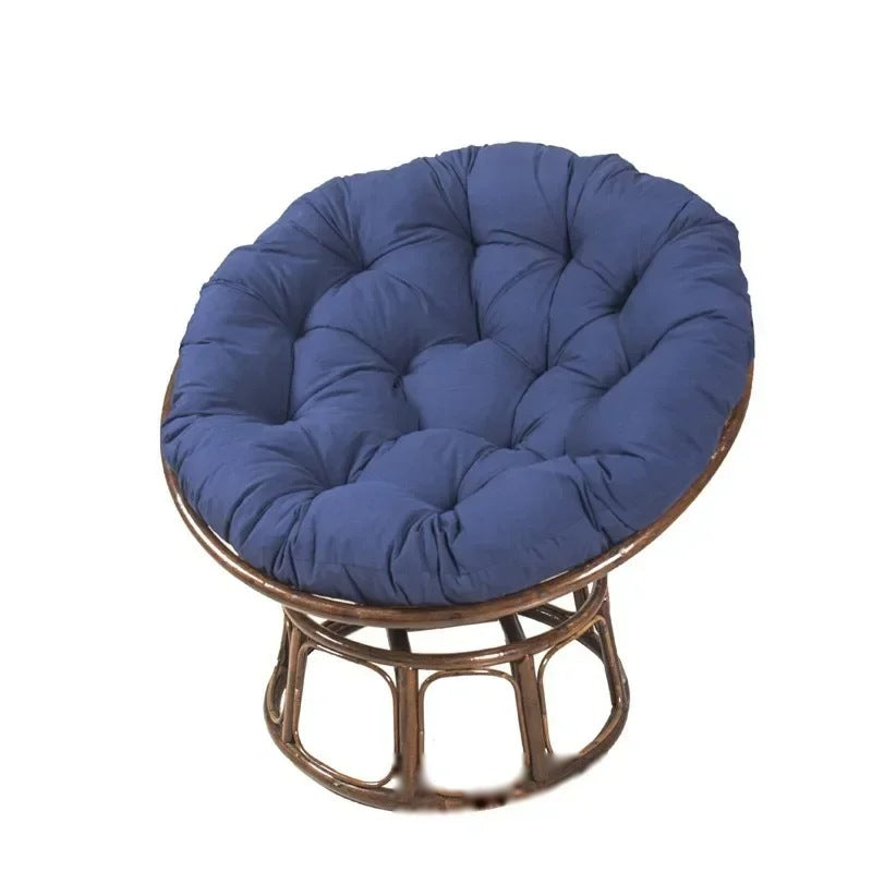PAPASAN — Coussin rond capitonné coloris Bleu marine posé sur un fauteuil papasan en rotin
