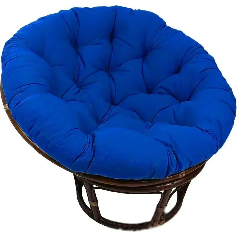 PAPASAN — Coussin rond capitonné coloris Bleu royal posé sur un fauteuil papasan en rotin