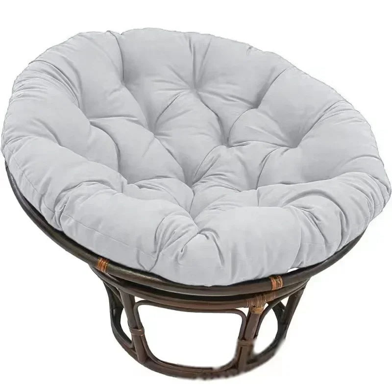 PAPASAN — Coussin rond capitonné coloris Gris clair posé sur un fauteuil papasan en rotin
