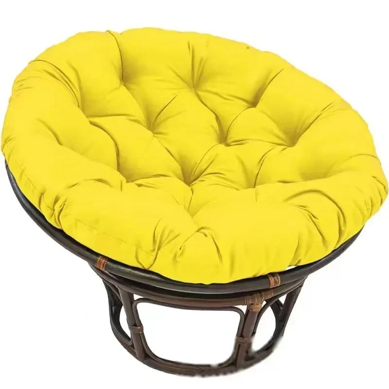PAPASAN — Coussin rond capitonné coloris Jaune posé sur un fauteuil papasan en rotin